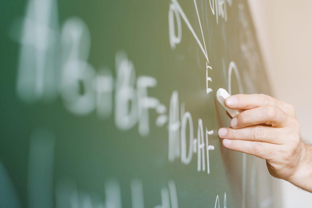 Popularne Pytania - aged math teacher writing formula chalkboard