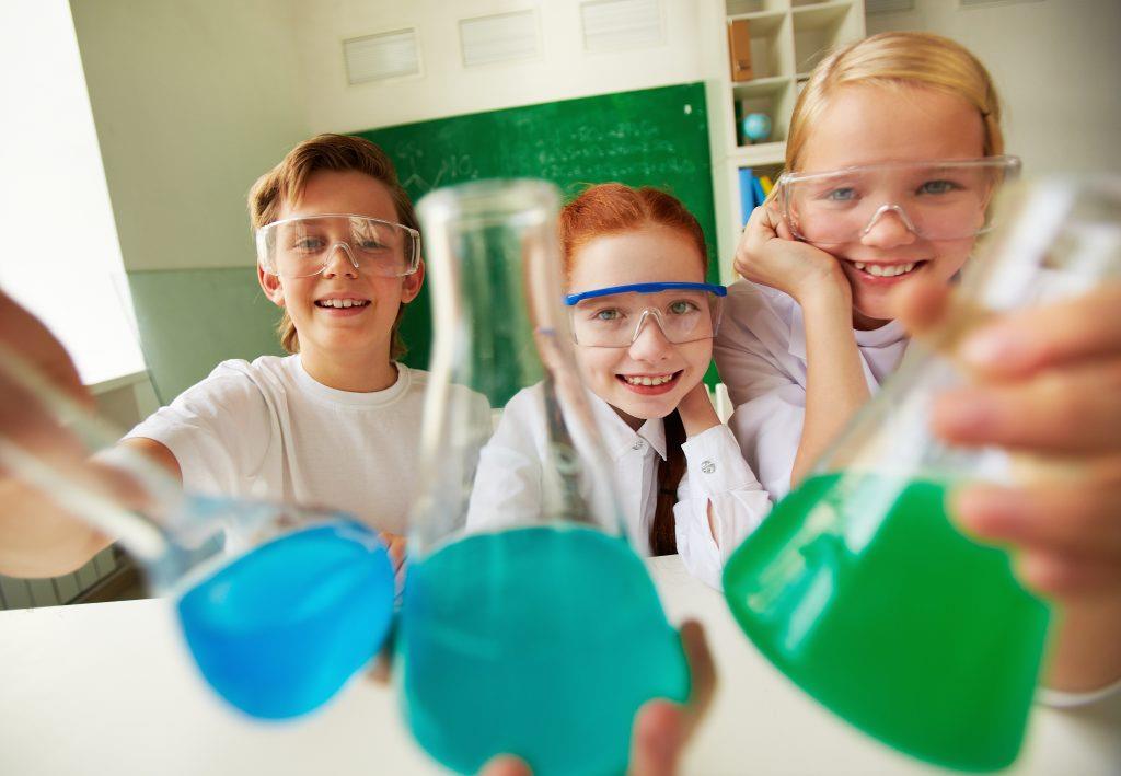 Szkoła Podstawowa Chemia - cheerful students holding flasks with liquids